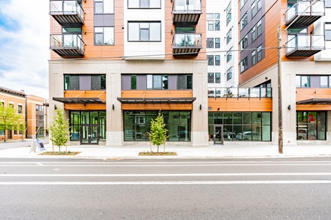 A modern multi-story building with balconies and glass doors.