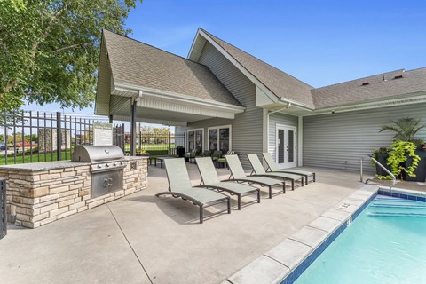 A house with a pool and lounge chairs.