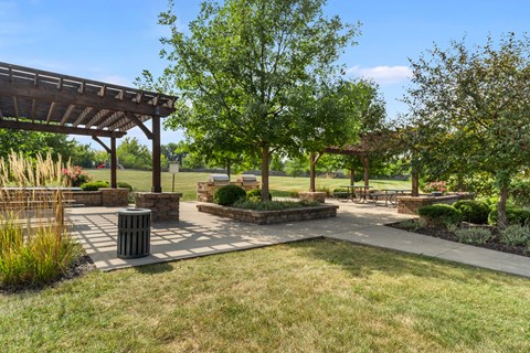A park with a pavilion, benches, and trees.