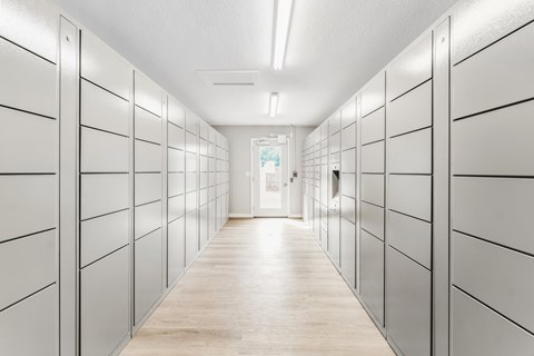 A long hallway with white lockers on both sides.