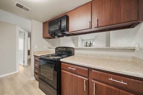 A kitchen with a black oven and microwave above it.