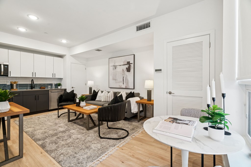 A modern living room with a black chair and a white table.