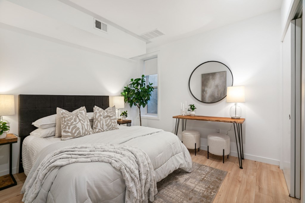 A bedroom with a large bed and a desk with a chair.