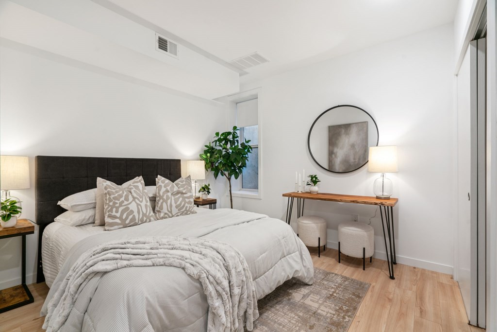 A bedroom with a large bed and a desk with a chair.