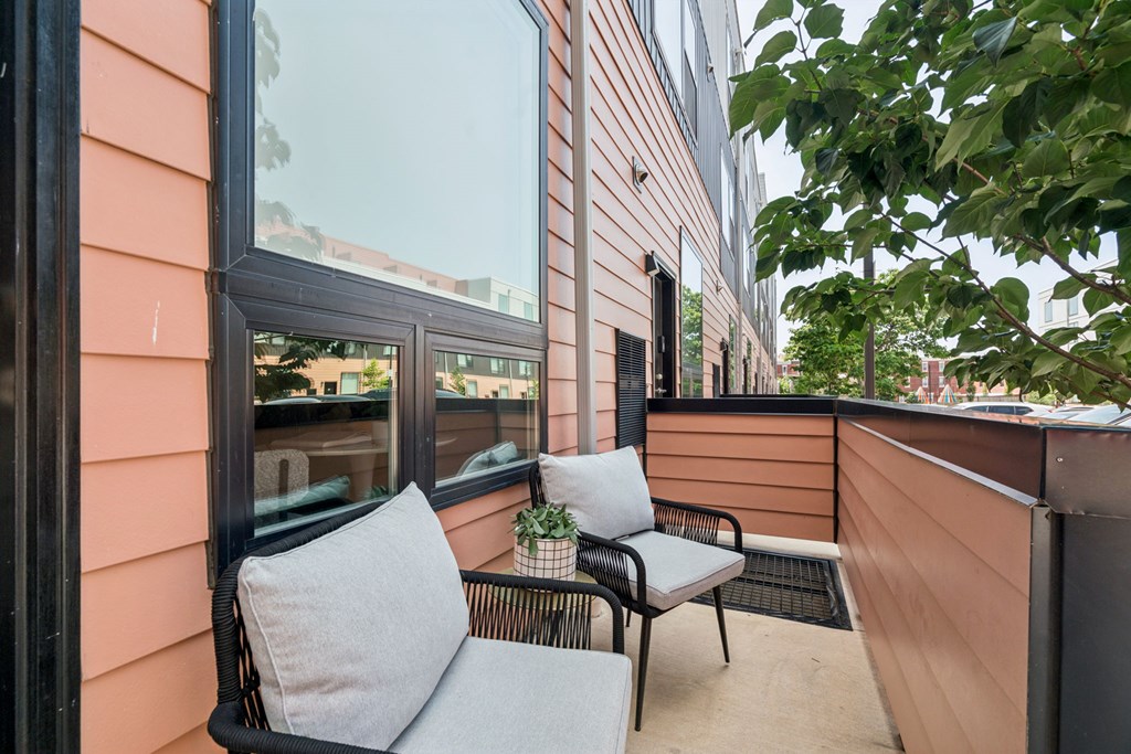 A balcony with a chair and a cushion.