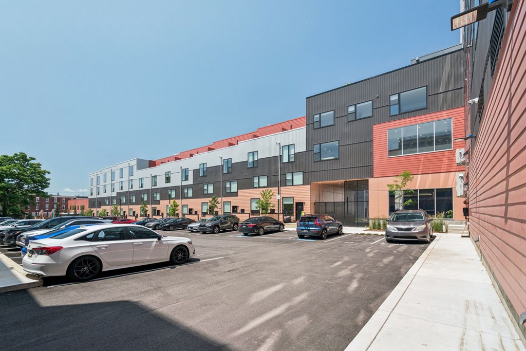 A parking lot with cars and a building in the background.