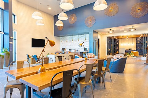 A modern dining room with a long wooden table and chairs.
