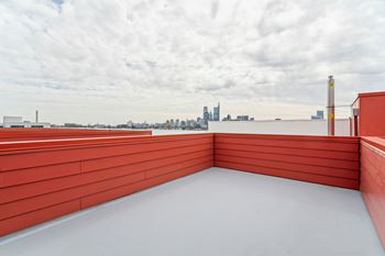 A red-roofed building with a view of a city skyline in the distance.