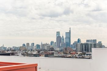 A city skyline with tall buildings and a cloudy sky.