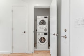 A white door is open to a laundry room with a washer and dryer.