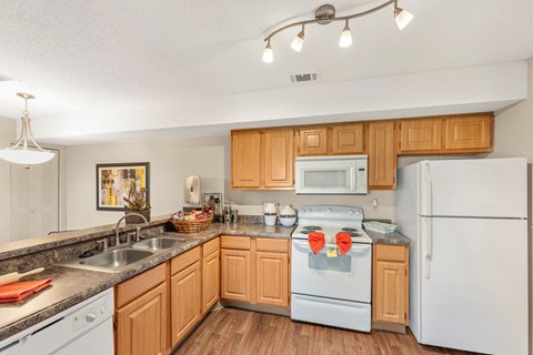 A kitchen with wooden cabinets and white appliances.