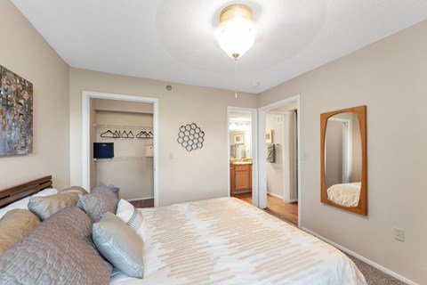 A bedroom with a large bed and a mirror on the wall.