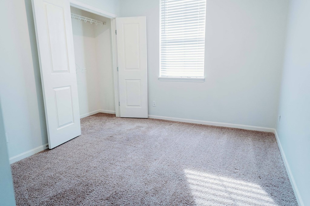an empty room with a closet and a window