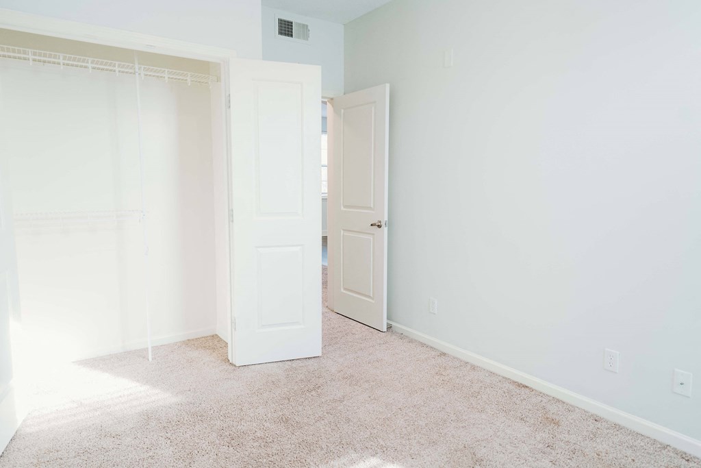 an empty room with a closet and an open door