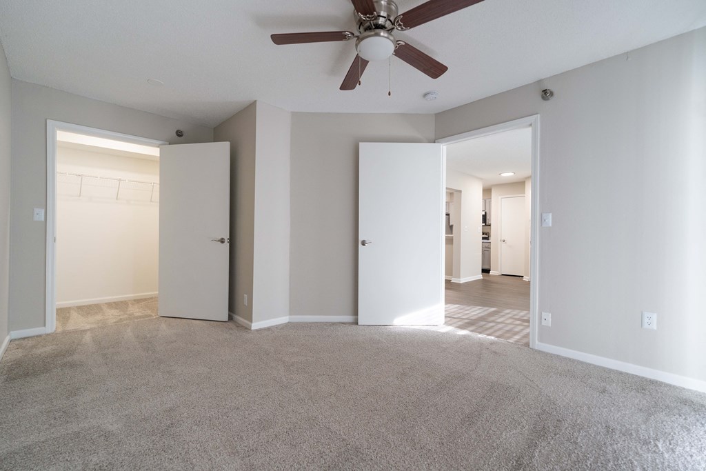 an empty living room with a ceiling fan