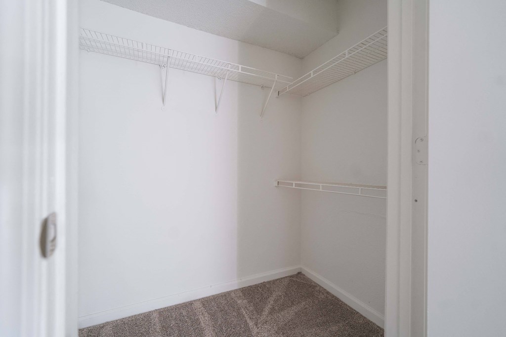 an empty room with white walls and a white closet