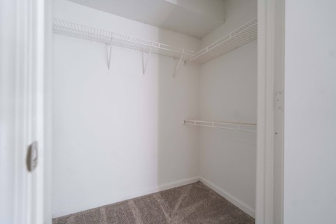 an empty room with white walls and a white closet