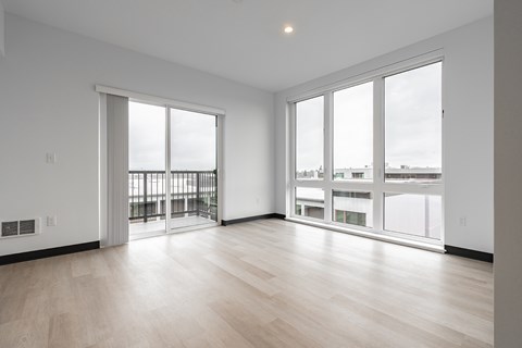 A spacious room with a view of the city through large windows.