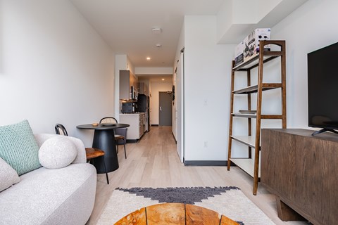 A living room with a white couch and a wooden bookshelf.