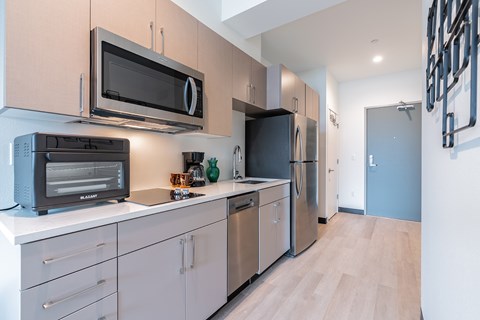 A kitchen with a black microwave above a black toaster oven.