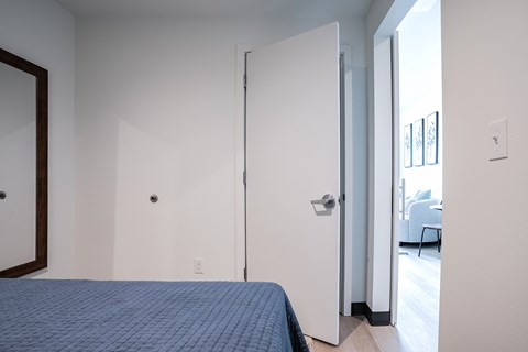 A bedroom with a bed and a mirror on the wall.