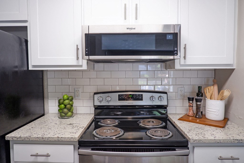 1 Park Central Apartments, Peachtree Corners, Georgia cozy kitchen with white cabinets and a stainless steel stove