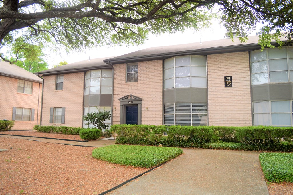 an apartment building with a walkway in front of it