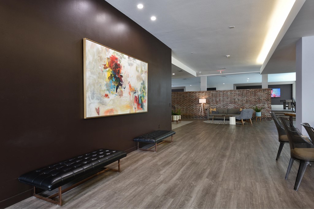 A modern living room with a large painting on the wall and a bench in the foreground.