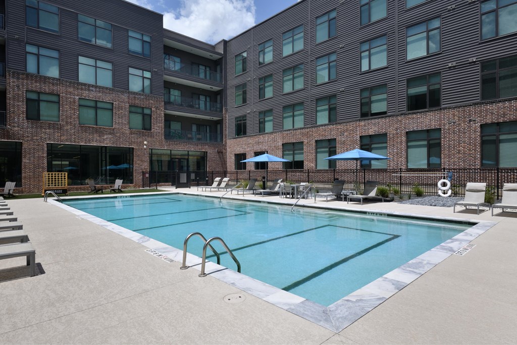 A swimming pool in front of a brick building.