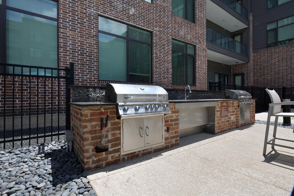 A brick wall with a grill on top of it.