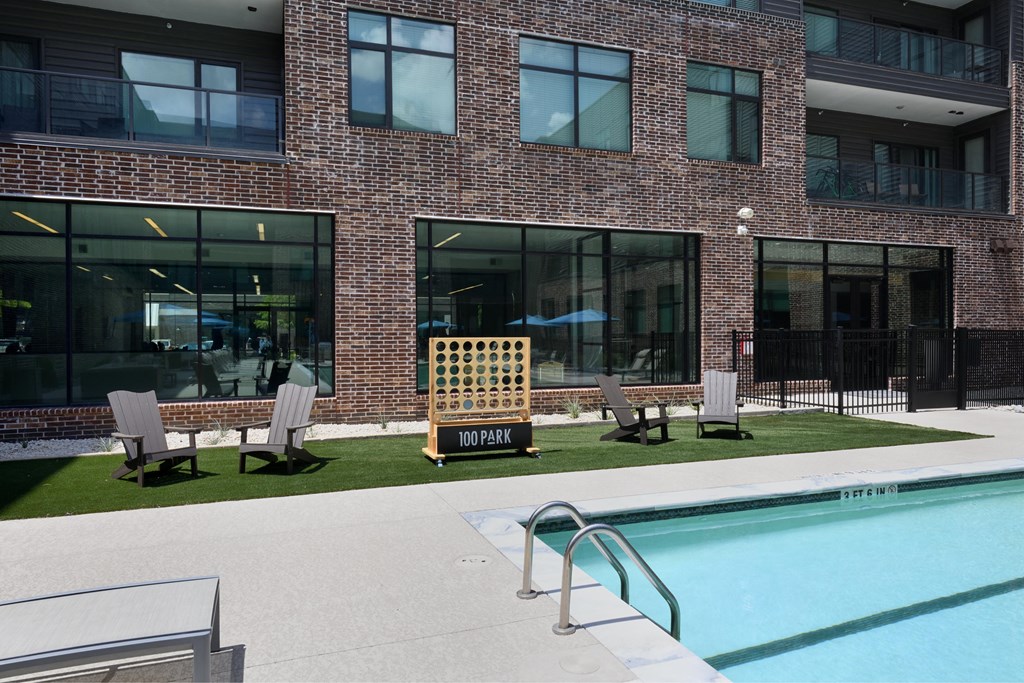 A brick building with a pool in front.