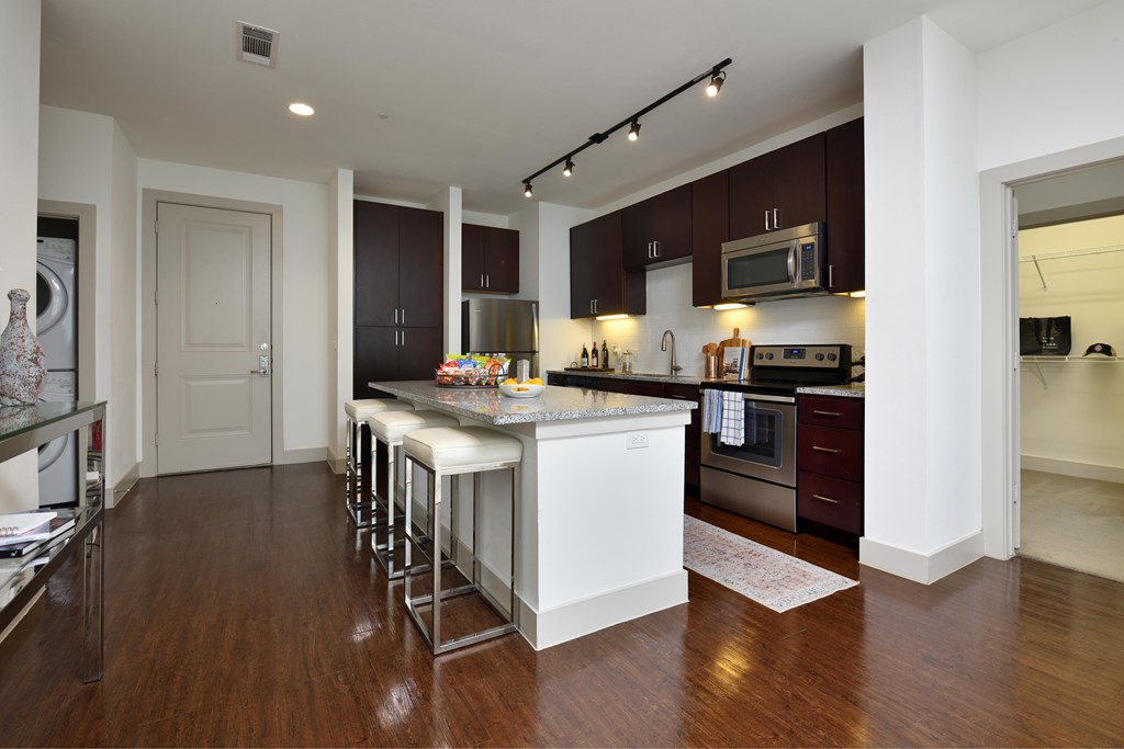 A kitchen with white cabinets and a wooden floor.