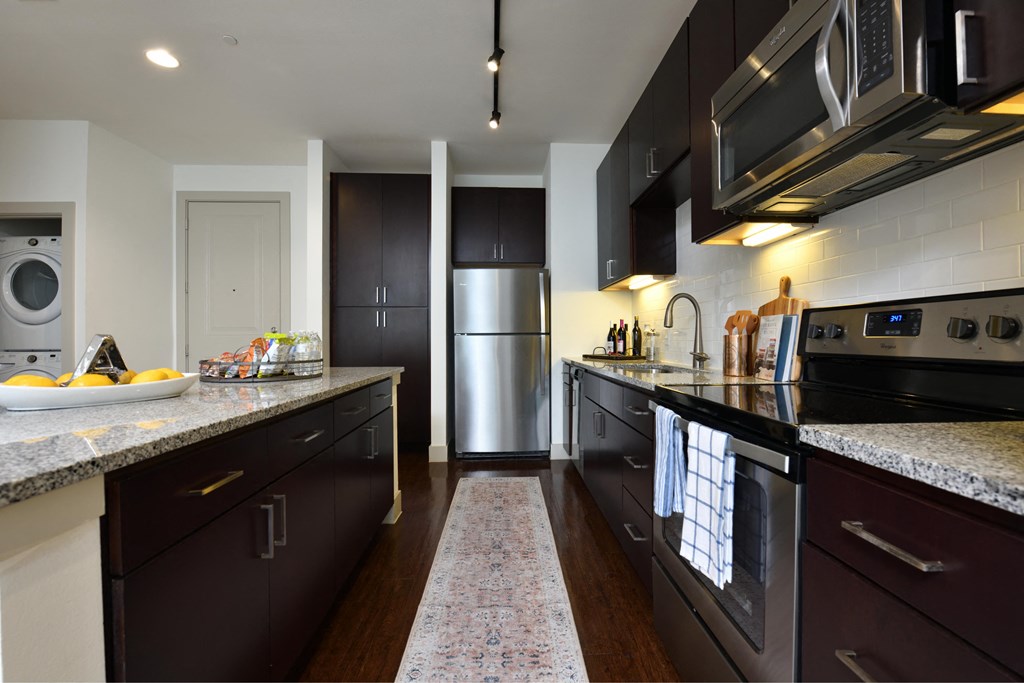 A kitchen with dark brown cabinets and stainless steel appliances.