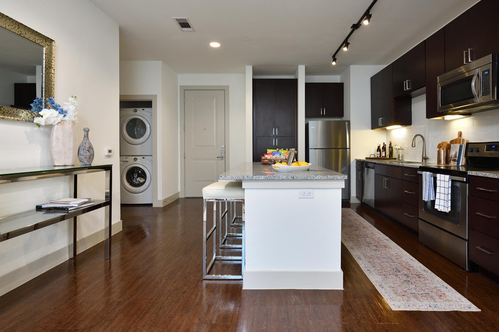 A modern kitchen with a white island in the middle.