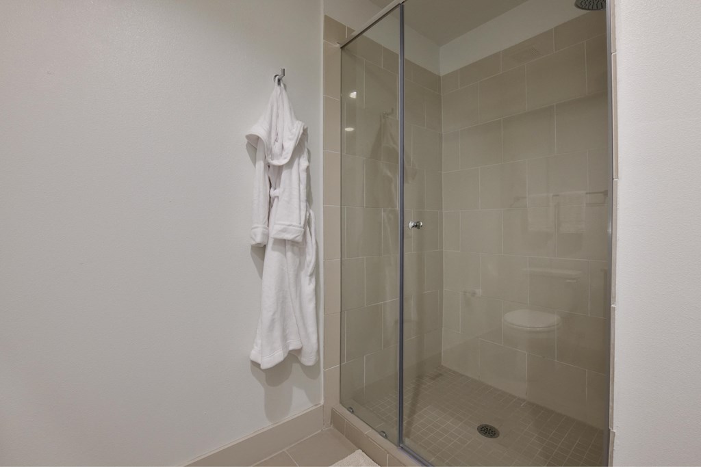 A white towel is hanging on a hook in a bathroom.