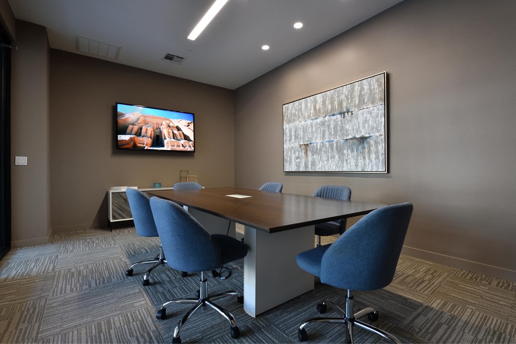 A conference room with a large table and chairs.