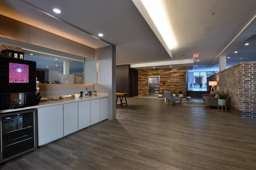 A modern kitchen with a wooden floor and white cabinets.
