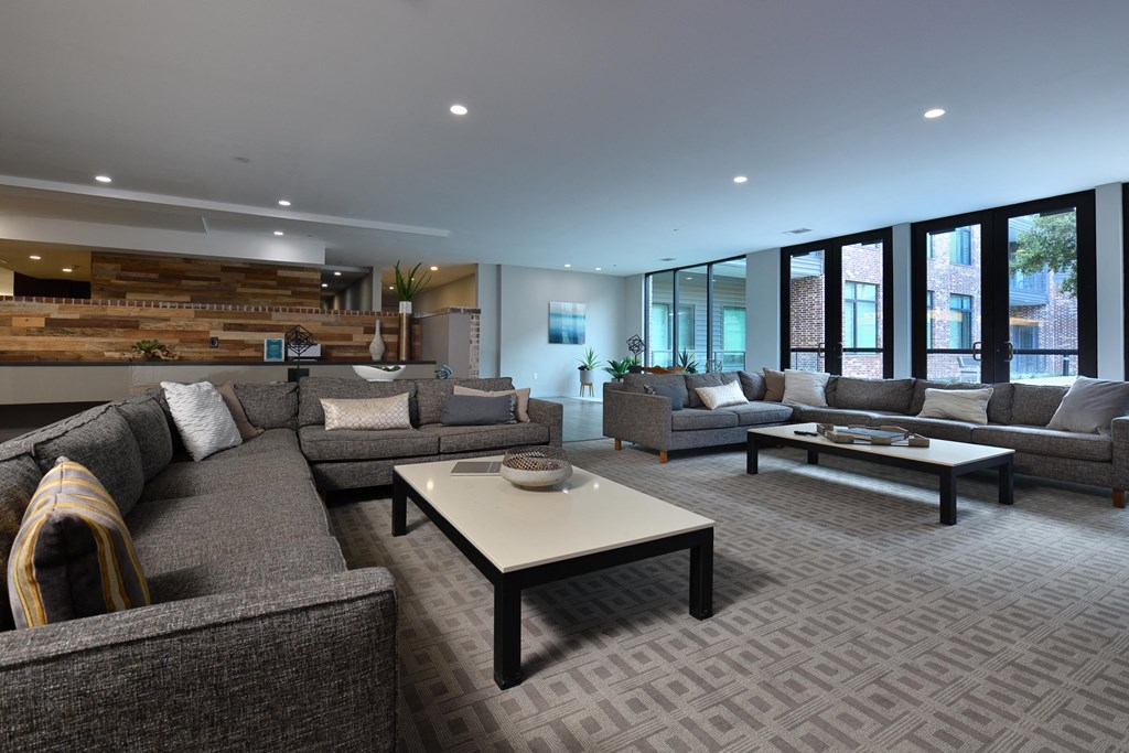 A modern living room with grey couches and a coffee table.