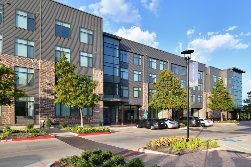 A modern building with a parking lot in front.