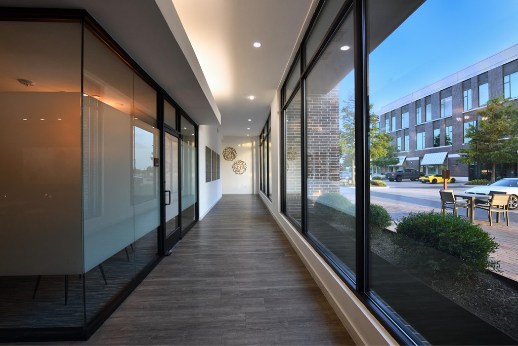 A long hallway with glass doors and windows on one side.