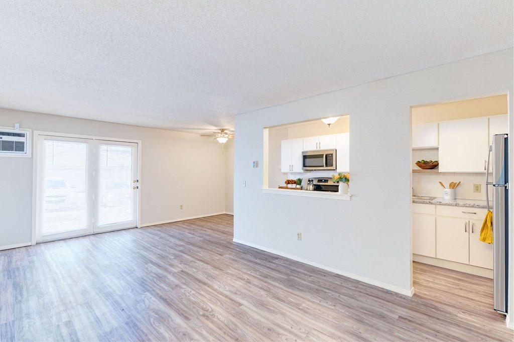 the spacious living room and kitchen of an apartment