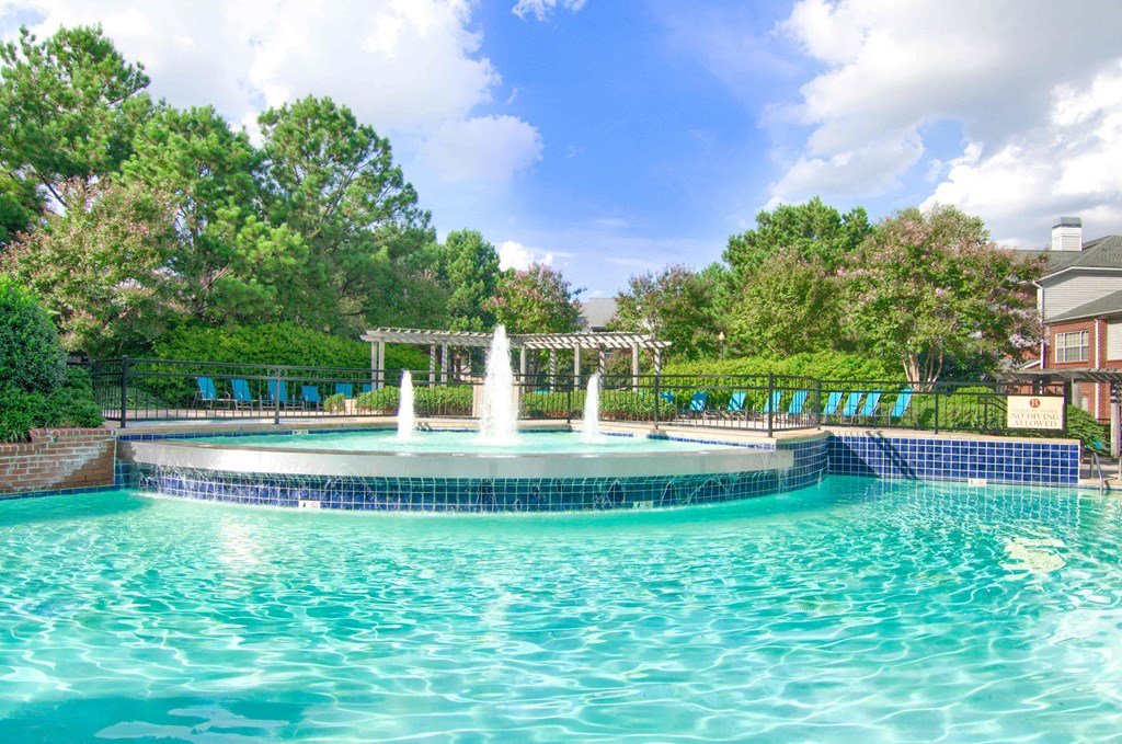 Enclave at Wolfchase Apartments in Cordova Tennessee photo of a fountain in the middle of a pool with a pergola in the background