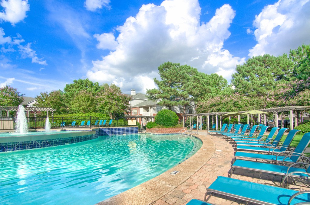 Enclave at Wolfchase Apartments in Cordova Tennessee photo of a resort style pool with chaise lounge chairs and a fountain