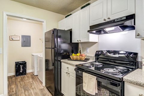 a kitchen with white cabinets and black appliances and a black refrigerator