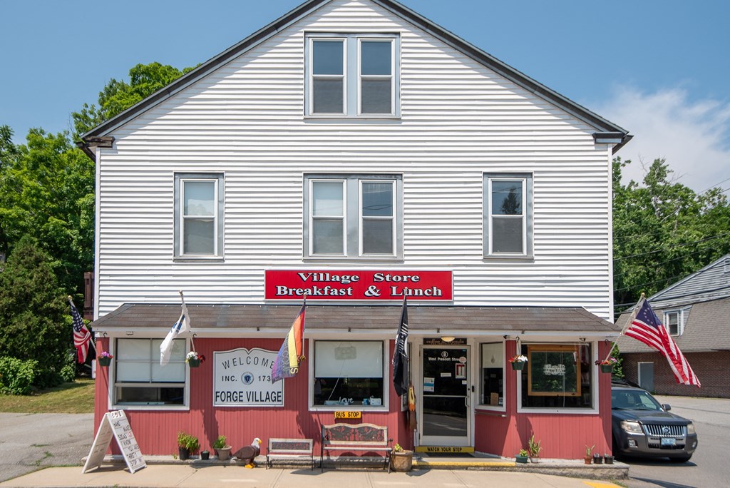 a white building with a red sign that reads wilkes store breakfast  lunch