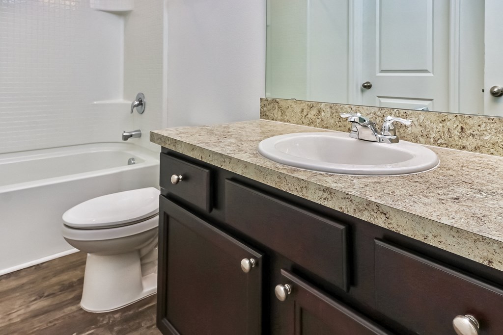 A bathroom with a white toilet and a marble countertop.
