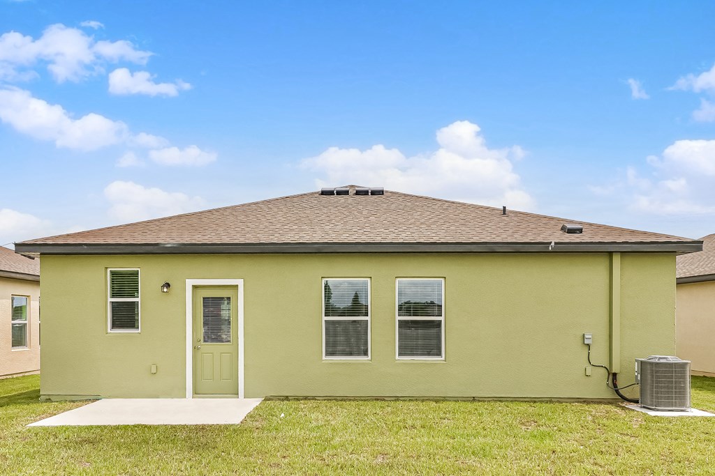 A green house with a white door and windows.