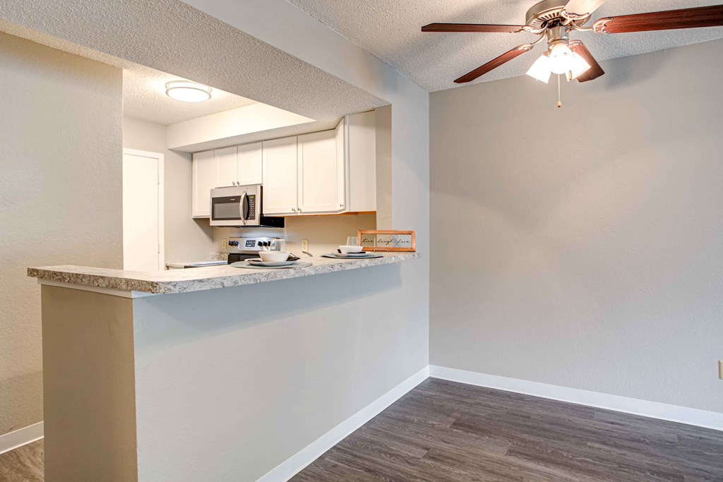 a kitchen with a counter and a ceiling fan