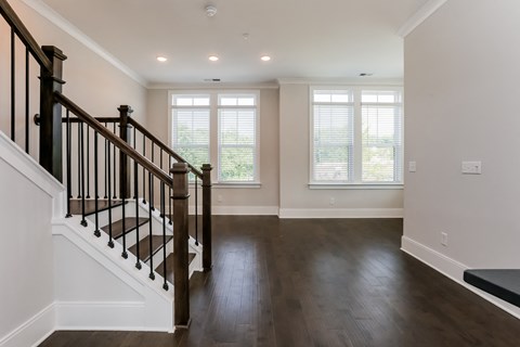 A spacious room with a staircase leading to the upper level.