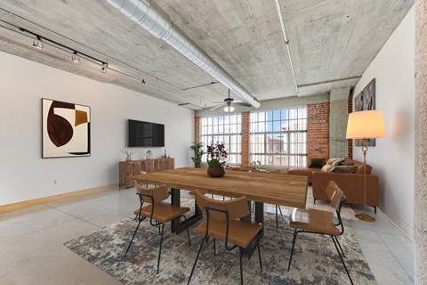 A dining room with a long wooden table and chairs.